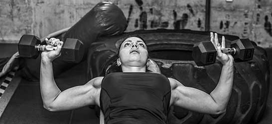 Woman doing benchpress with single weights